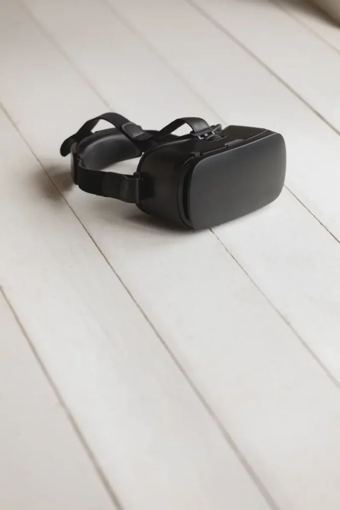 Virtuelle Besichtigungen 8 Fotograf Hannover - Ein schwarzes Virtual-Reality-Headset liegt auf einer hellen Holzoberfläche. Das Headset hat verstellbare Riemen und eine glatte Außenseite. Fotograf in der Nähe.